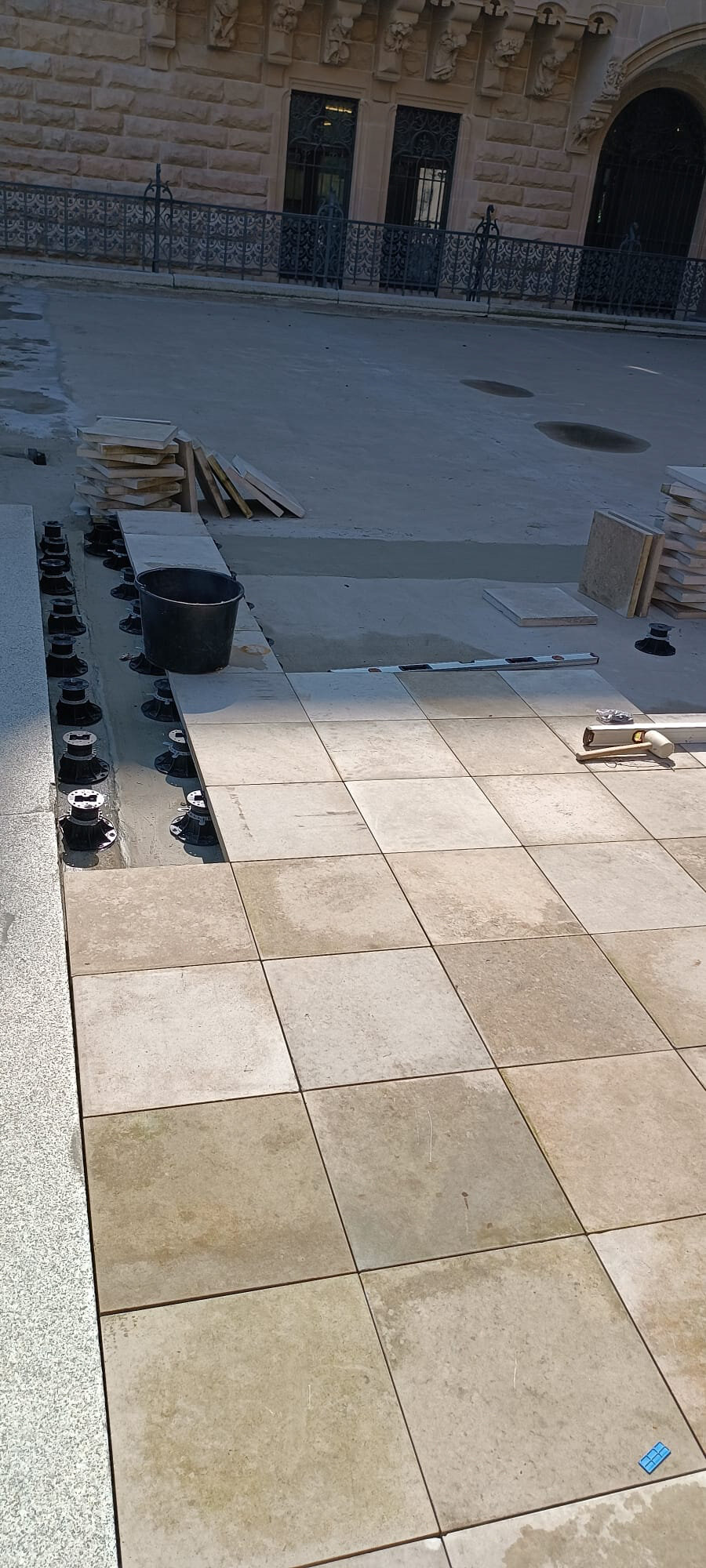 Installation of a raised deck terrace on pedestals in a courtyard