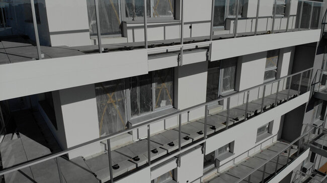 Elevated terraces on adjustable pedestals on balconies in a multi-family building