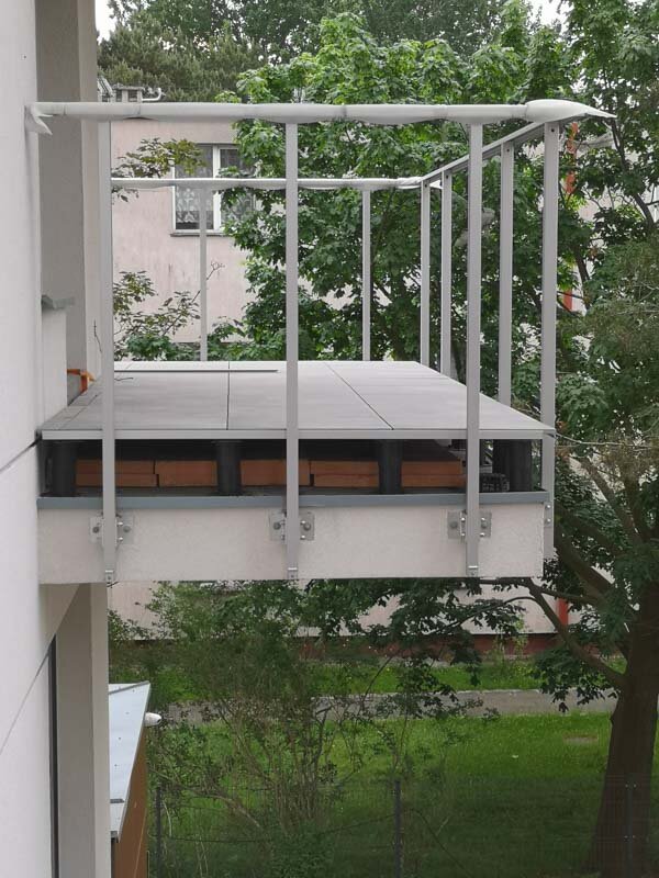 Adjustable pedestals on a balcony in a raised deck terrace system support pads