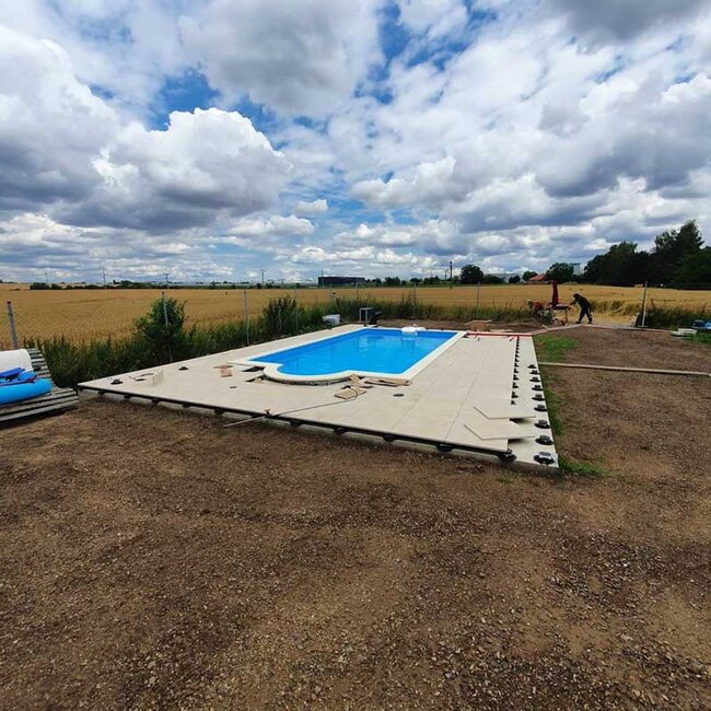Swimming pool being built on the ground with pavers laid on adjustable pedestals