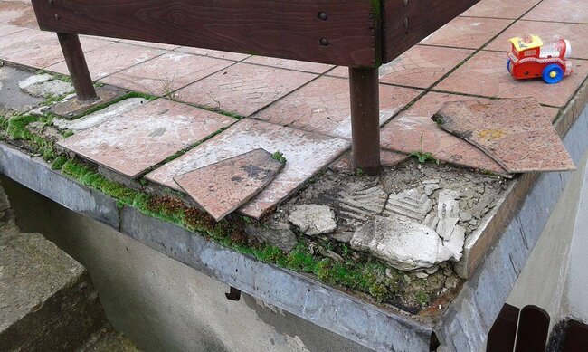 Falling and crumbling pavers on a traditional glued terrace
