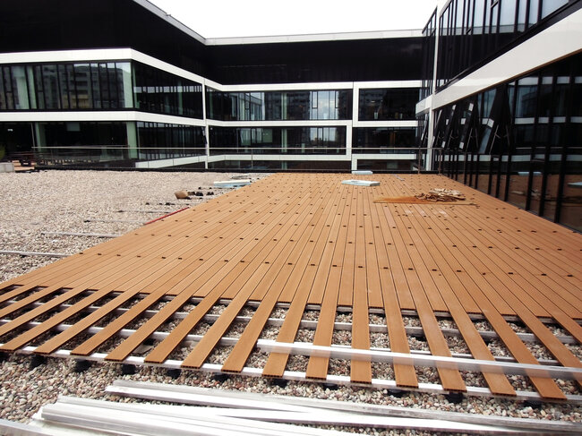 Elevated terrace on a usable roof with aluminum joists and composite decking boards on solver pedestals