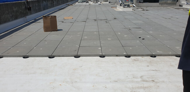 Flat usable roof with a raised deck terrace with pavers laid on fixed-height terrace pedestals