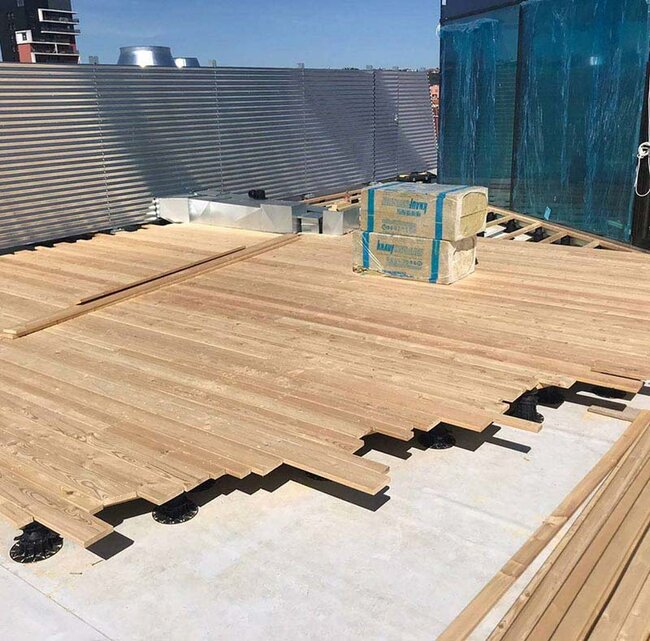 Construction of a natural wood deck terrace on pedestals