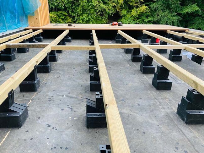 Adjustable pedestals on a raised deck terrace with evenly spaced terrace joists