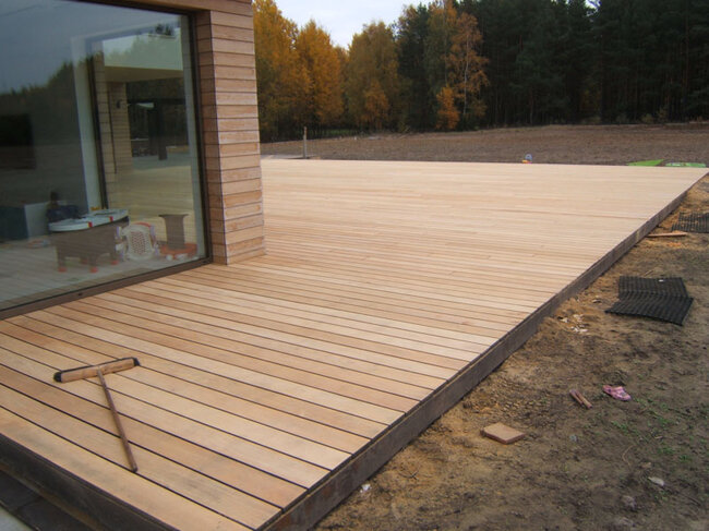 Implementation of a raised deck terrace on the ground with natural wood boards