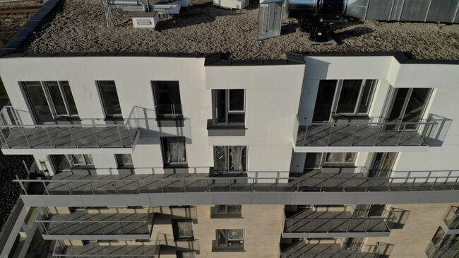 Multi-family building with balconies in a raised deck terrace system