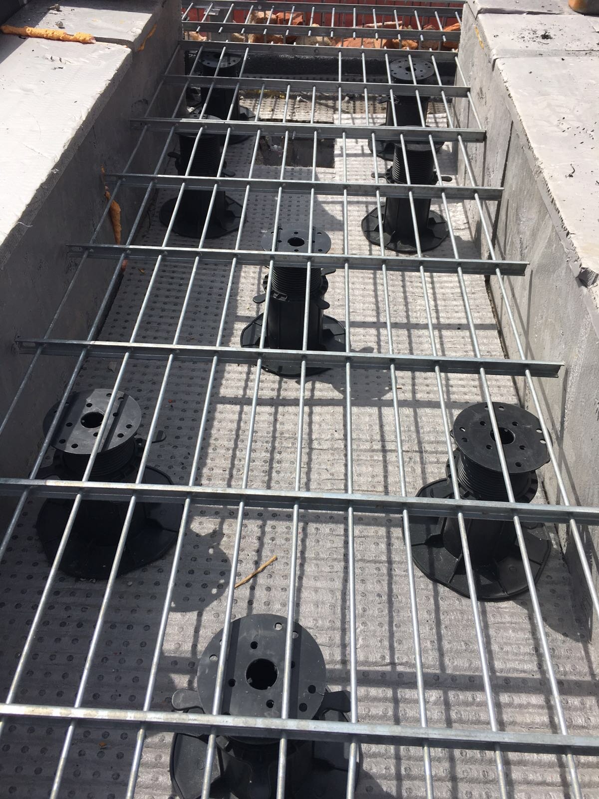 Pedestals for gratings on a terrace or raised deck roof