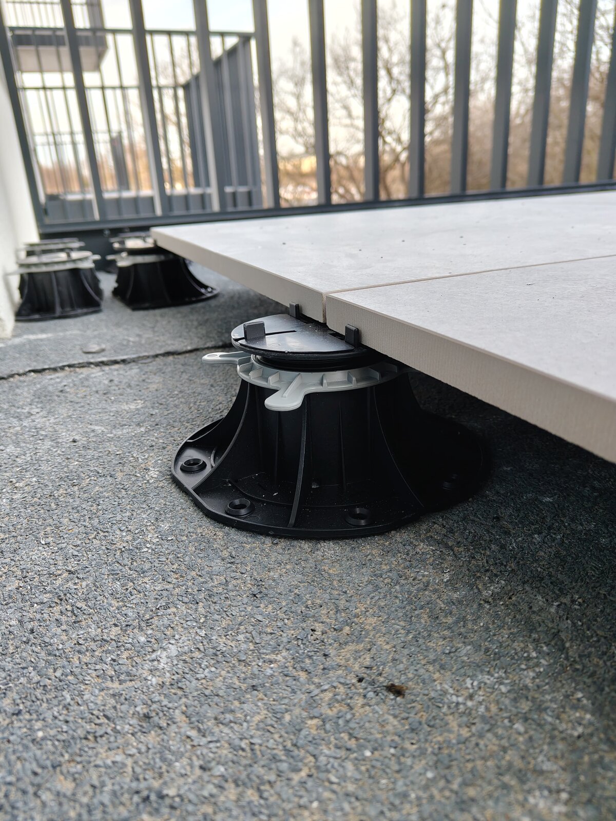 Adjustable pedestal standard under terrace paver laid on torch-applied roofing membrane