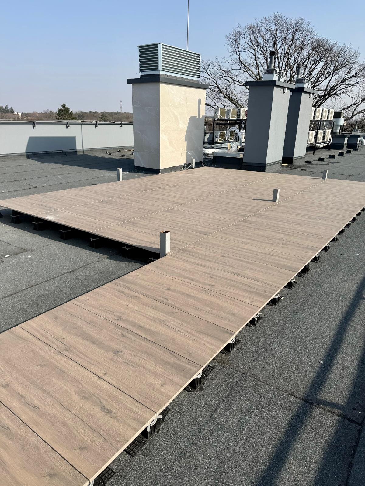 Terrace pedestals on a flat roof with wood-look pavers