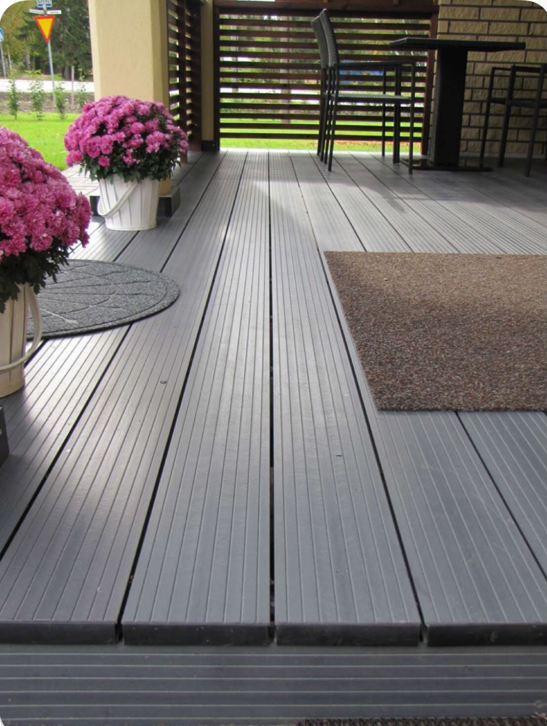 Wooden deck terrace with an olive tree and a garden bench.