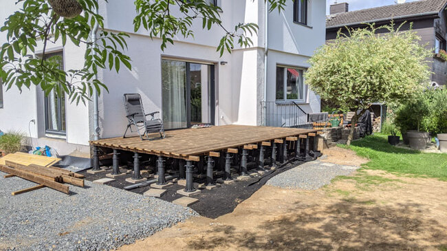 Construction of a wooden terrace on high adjustable pedestals at the house