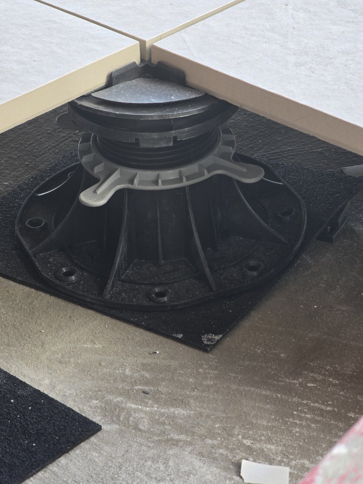 Adjustable support pad for raised deck terrace pavers.