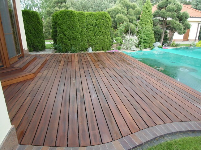 Finishing of a garden terrace with wooden boards and an edging made of paving stones.