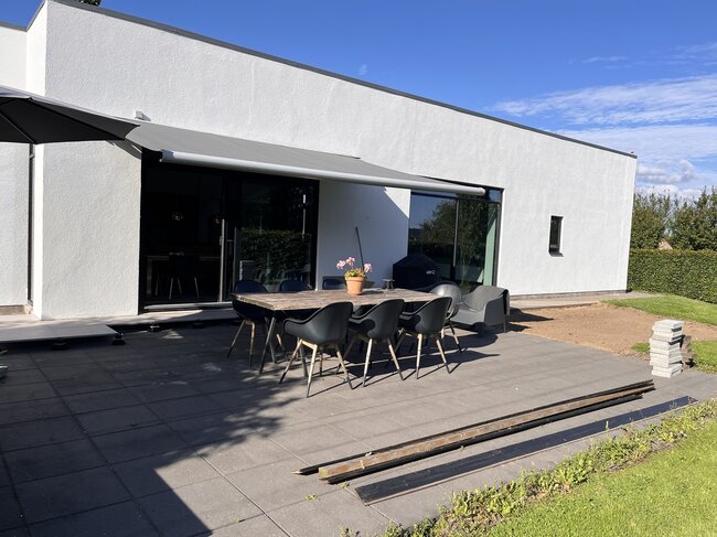 Modern terrace with concrete pavers at a white house
