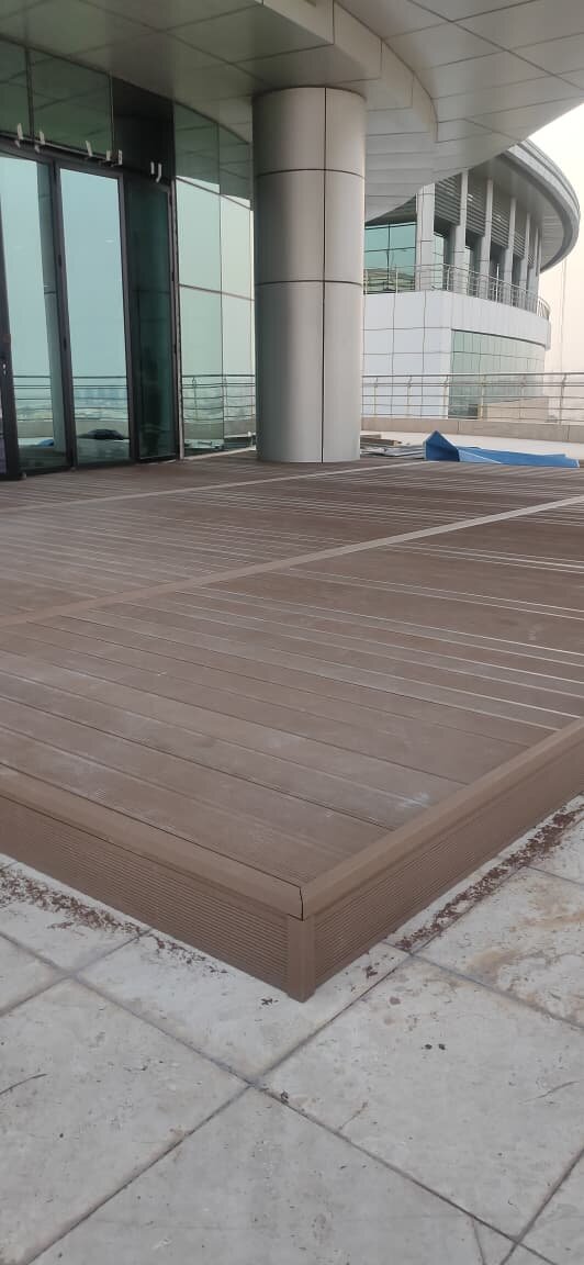Deck made of composite boards on an elevated terrace next to a modern building