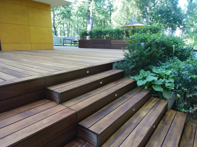 Wooden terrace with stairs and lighting in the garden