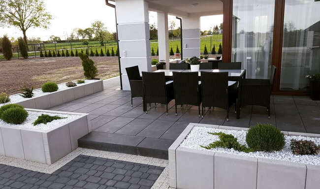 Modern terrace with dark raised deck pavers and garden furniture