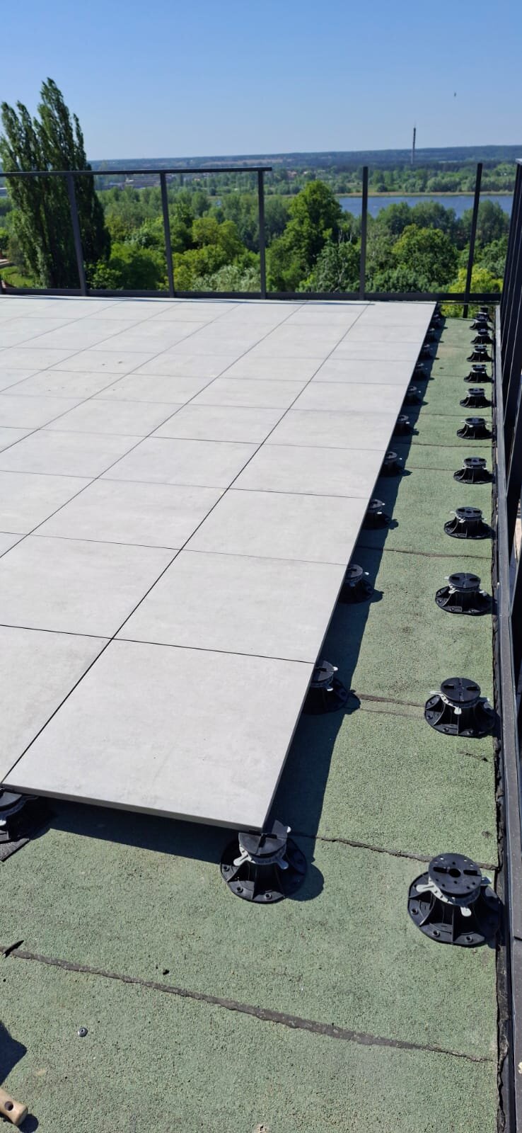 Installation of a raised deck terrace with ceramic pavers on adjustable pedestals