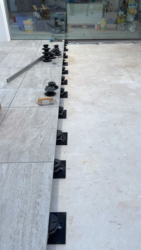 Laying terrace pavers on adjustable pedestals