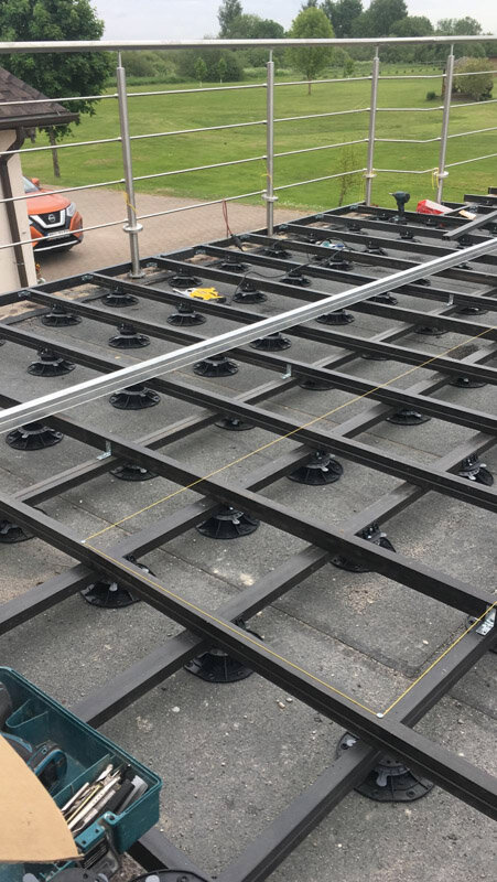 Installation of the terrace substructure with joists on adjustable pedestals