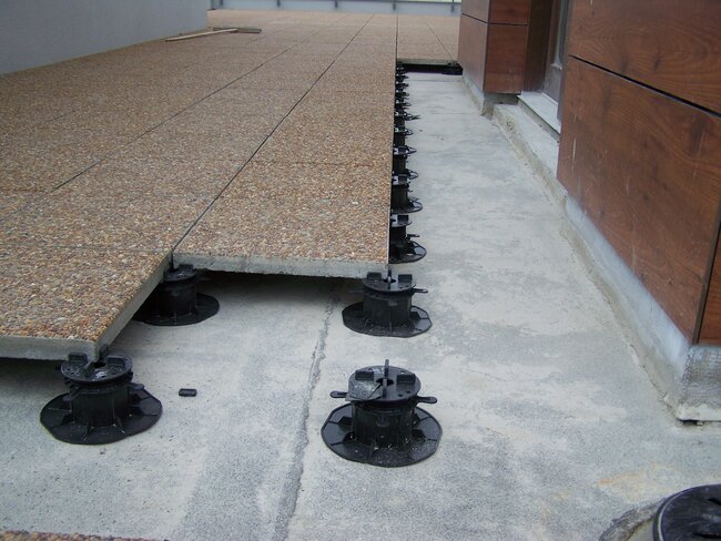 Terrace pavers with aggregate on black adjustable pedestals