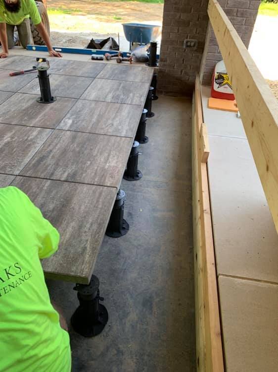 Installation of a raised floor with concrete pavers on adjustable pedestals