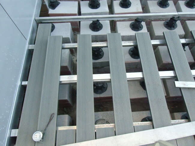 Construction of a composite deck on joists and terrace pedestals