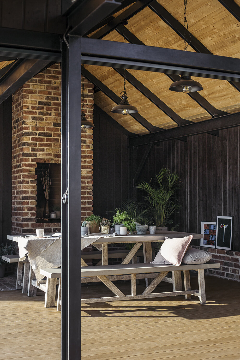 Covered terrace with wooden flooring and garden furniture