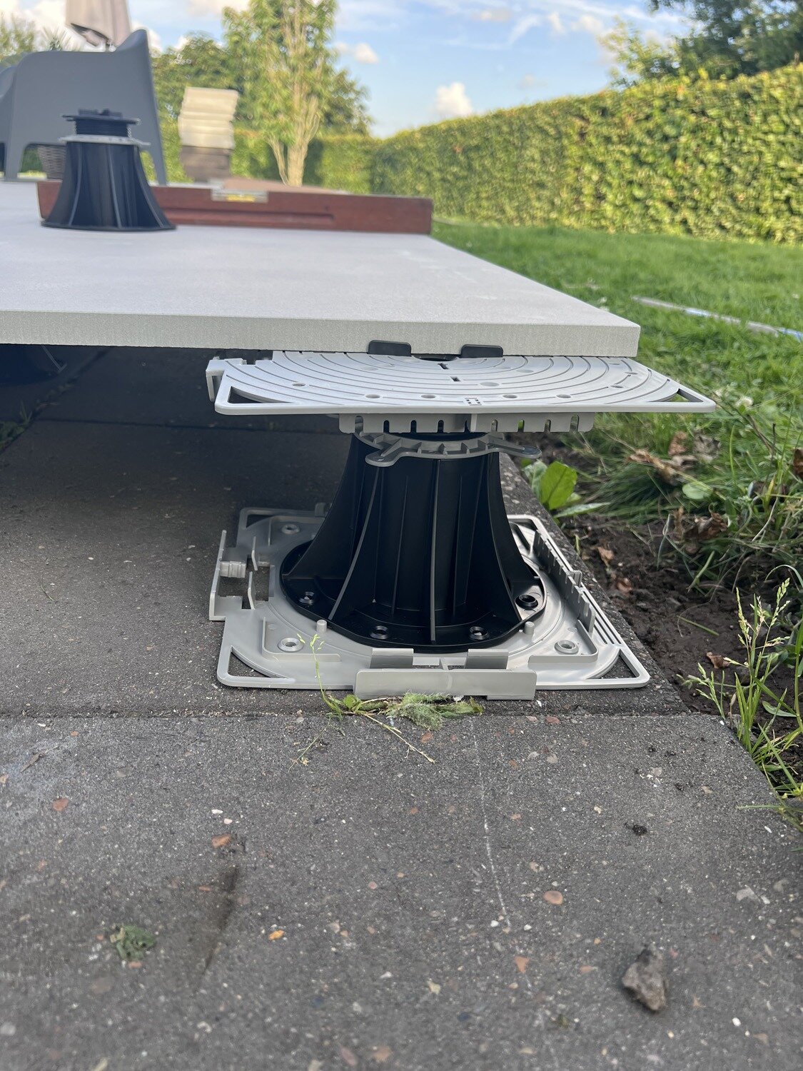 Paver supported on an adjustable pedestal with a support pad