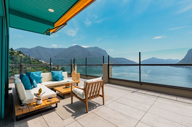 Modern elegant raised deck terrace with lounge furniture and a view of the lake