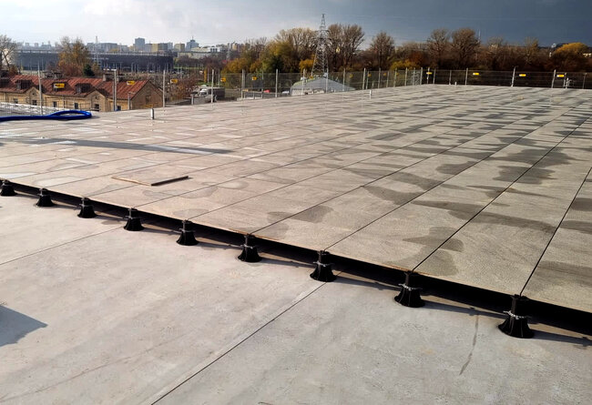 Raised deck terrace on the building's flat roof finished with pavers on pedestals