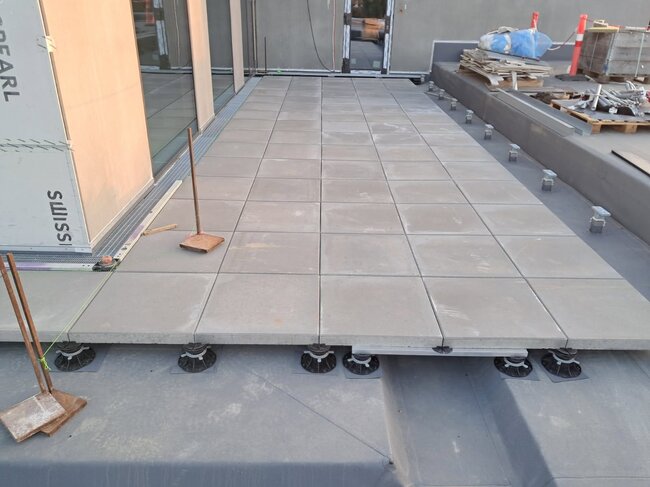 Long raised deck terrace with grey ceramic pavers with railing