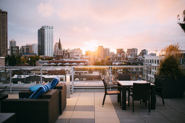 Modern rooftop terrace with garden furniture and a view of the city skyline