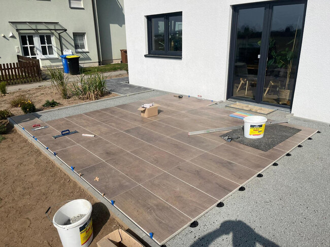 Construction of a raised deck terrace with wood-look porcelain tiles at a house