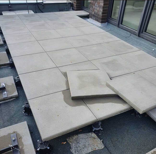 Montage of concrete terrace pavers on adjustable pedestals