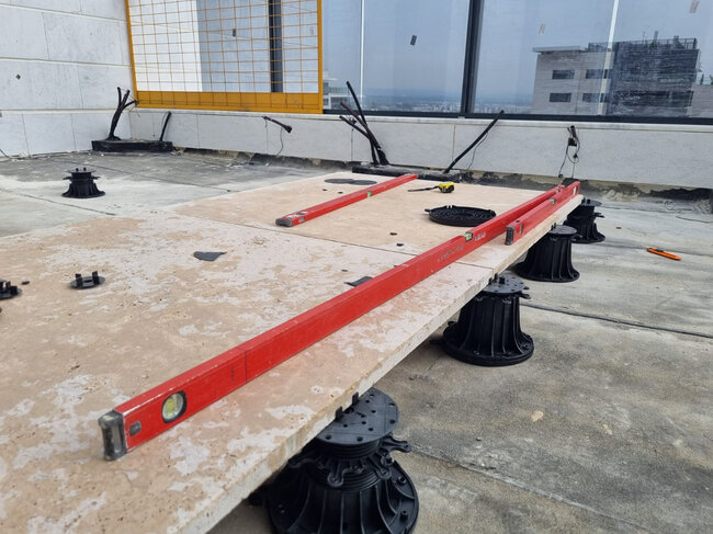 Leveling large-format terrace pavers on adjustable pedestals