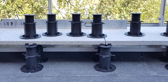 `Adjustable terrace pedestals positioned under terrace pavers`