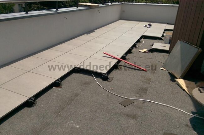 Photo from the installation of a raised deck terrace on pedestals using pavers.