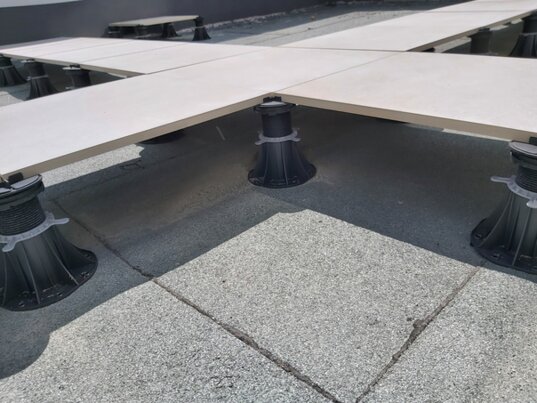 Photo showing a fixed-height support pad for pavers
