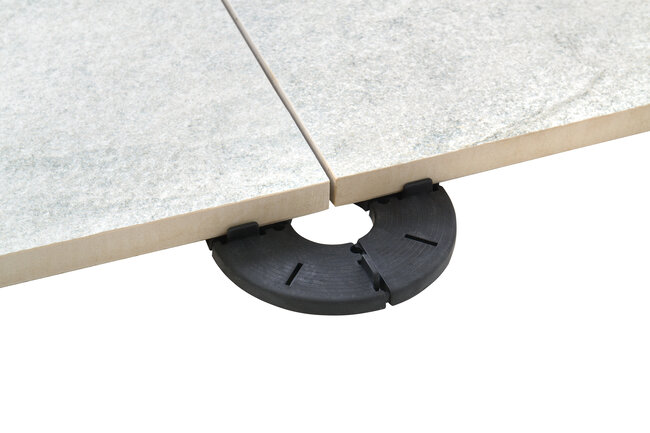 Photo showing the implementation of a terrace project with concrete pavers using fixed-height support pads for pavers