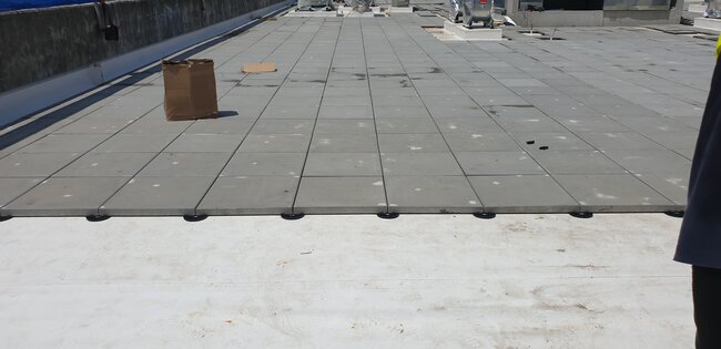 Photo showing a terrace laid on fixed-height support pads for pavers.