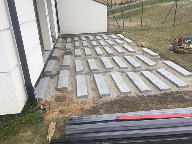 Selected substrate and laid concrete pavers prepared for a raised deck terrace on the ground