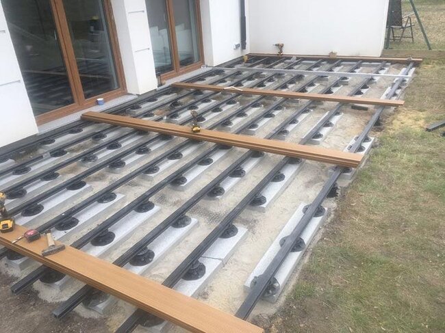 Adjustable pedestals arranged on concrete slabs on the ground and laying boards