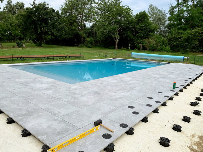 Terrace with pavers and a pool laid on the ground on a concrete screed on spiral solver pedestals