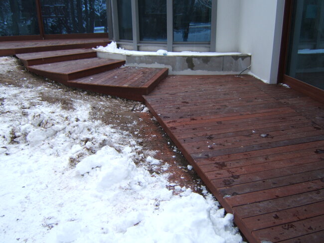 Wooden stairs and exotic terrace covered with snow in winter.