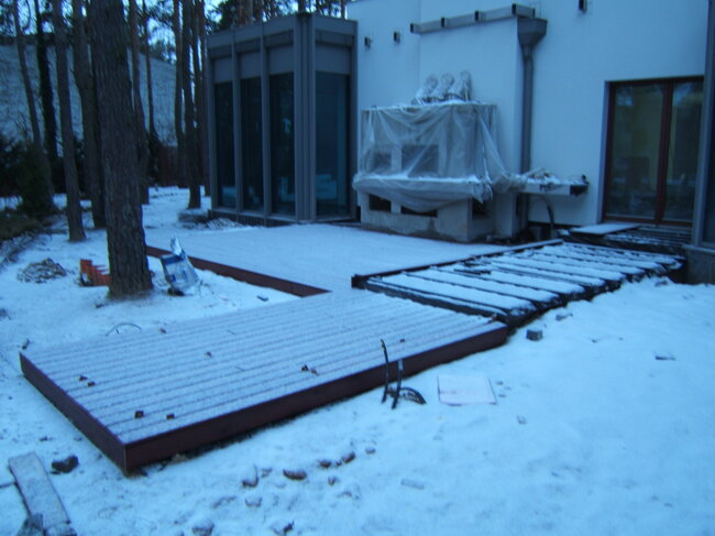 Construction of a wooden terrace at a modern house in winter.