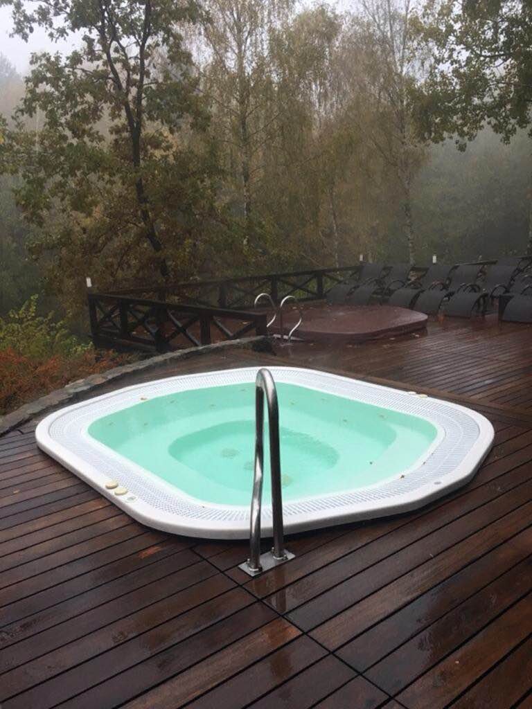 Built-in garden jacuzzi on a wooden terrace surrounded by forest.
