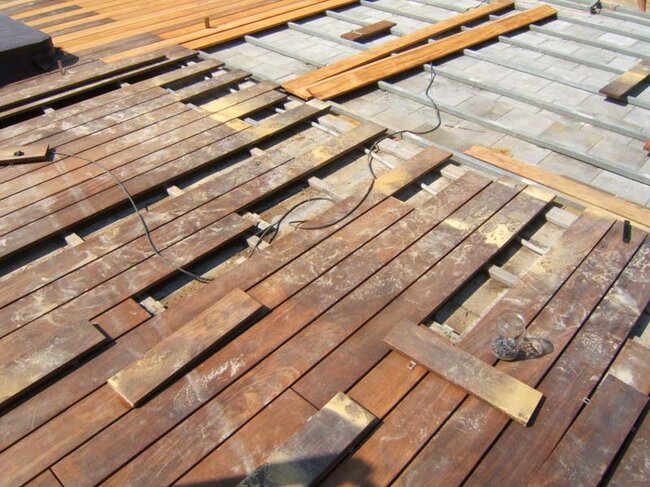 Installation and laying of wooden terrace boards on joists.