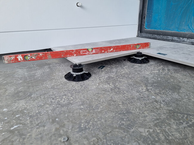 Level control of laid gres tiles on terrace pedestals.